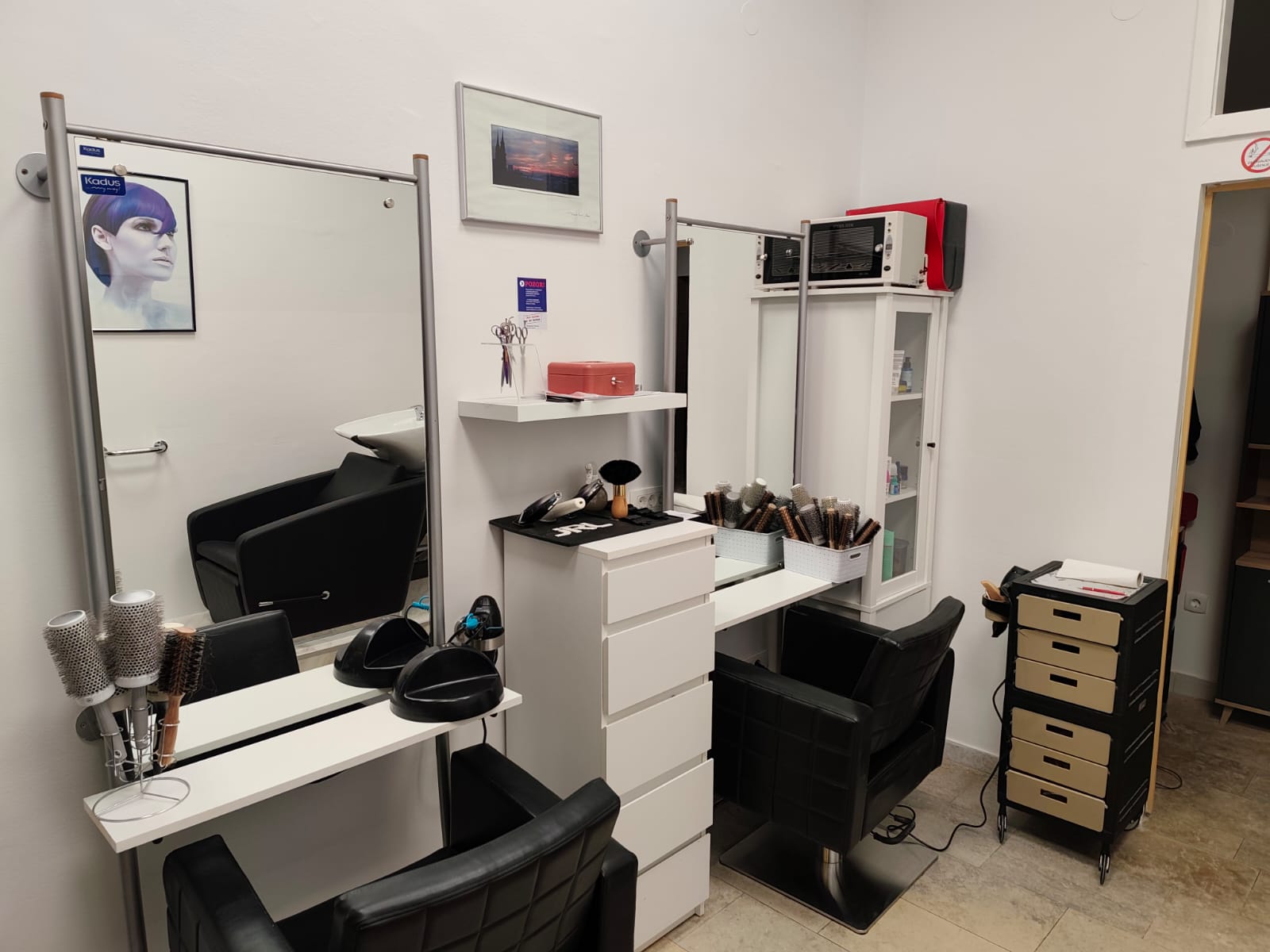 Dva radna mjesta u frizerskom salonu Martina u Zagrebu, s velikim ogledalima, crnim stolcima i četkama za feniranje.
